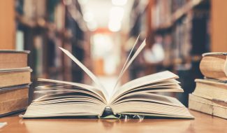 Book,In,Library,With,Old,Open,Textbook,,Stack,Piles,Of Book,In,Library,With,Old,Open,Textbook,,Stack,Piles,Of